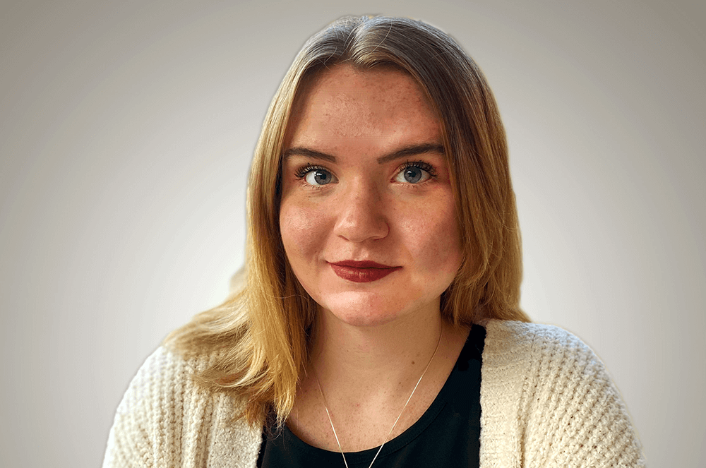 Woman in white sweater looking at camera